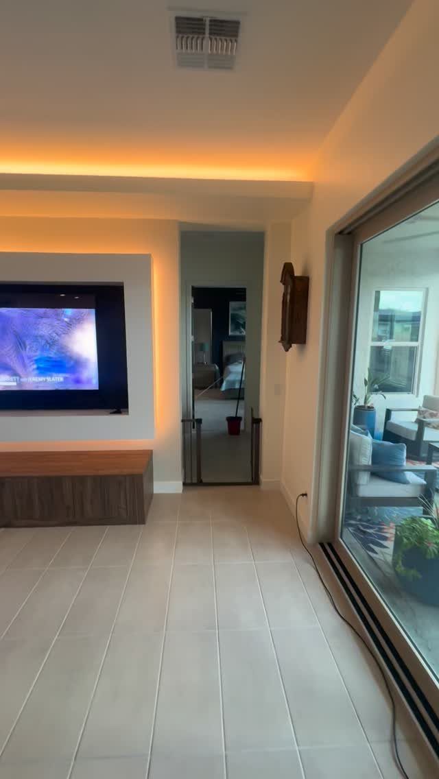 Built in Entertainment Center: 8 Design Ideas for Your Wall 5 A low-profile wooden entertainment center mounted below a television in a modern living room.