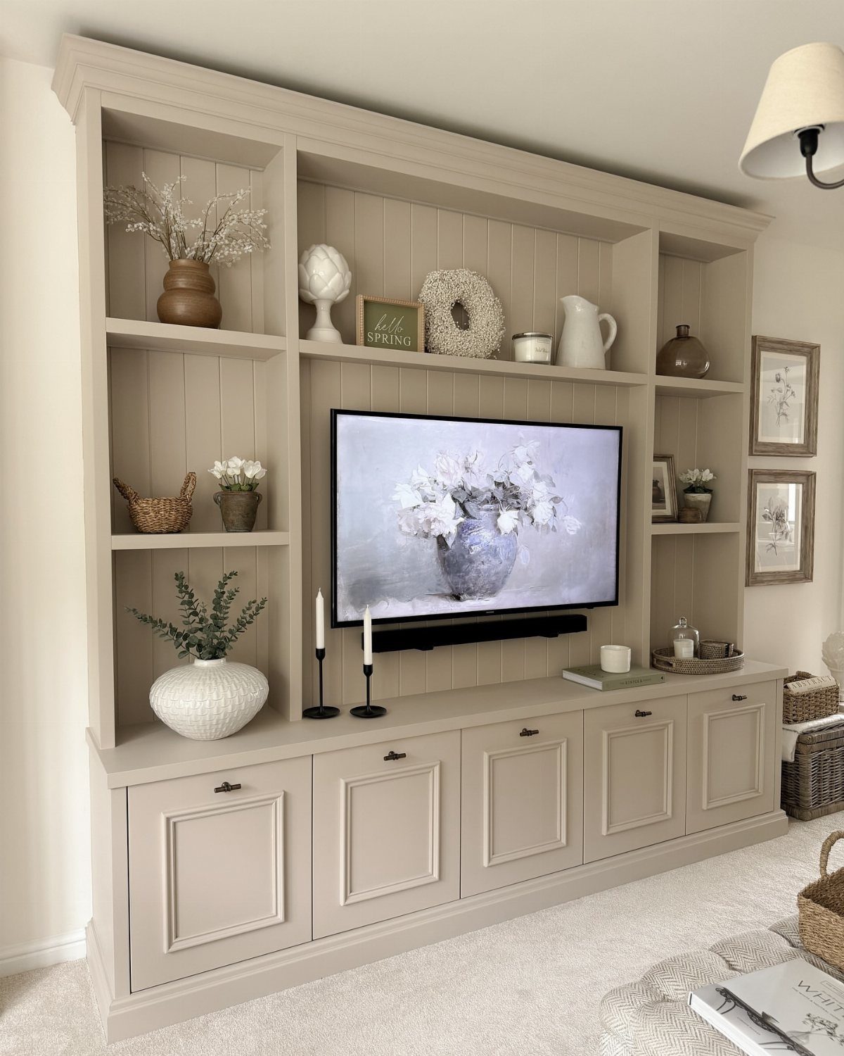 Built in Entertainment Center: 8 Design Ideas for Your Wall 9 A beige built-in entertainment center with open shelving and lower cabinets containing a television.