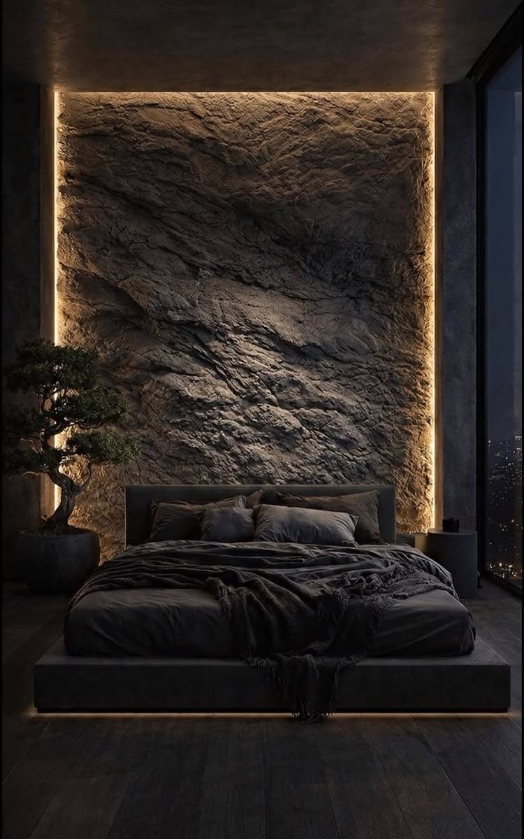 20 Dark Accent Wall Ideas to Try in Any Room 18 A textured dark stone accent wall illuminated by warm backlight behind a modern grey bed.