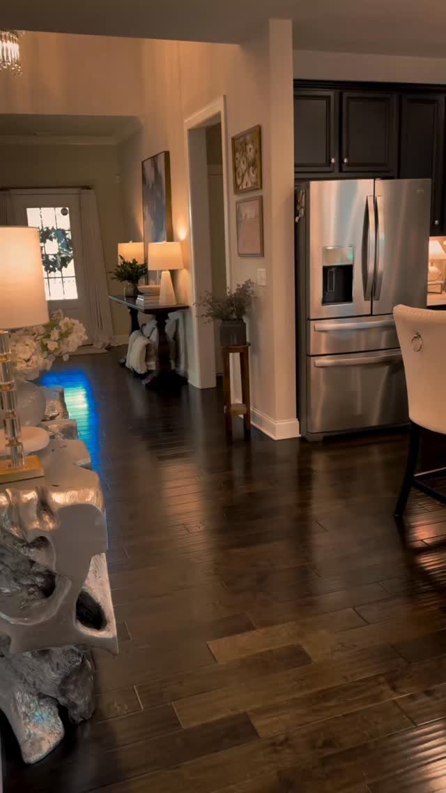 Dark hardwood flooring running through a modern home interior with furniture and kitchen appliances.