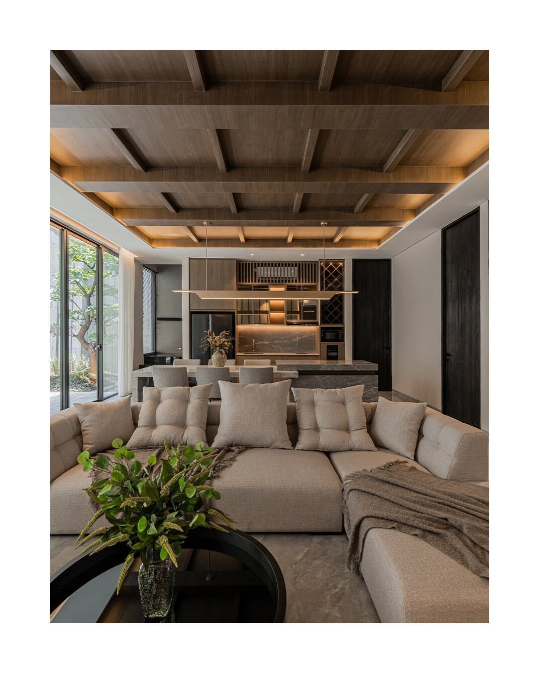 Floor to Ceiling Wall Paneling: 9 Rooms That Get It Right 4 Dark wood coffered ceiling with warm integrated lighting in a modern living room setting.