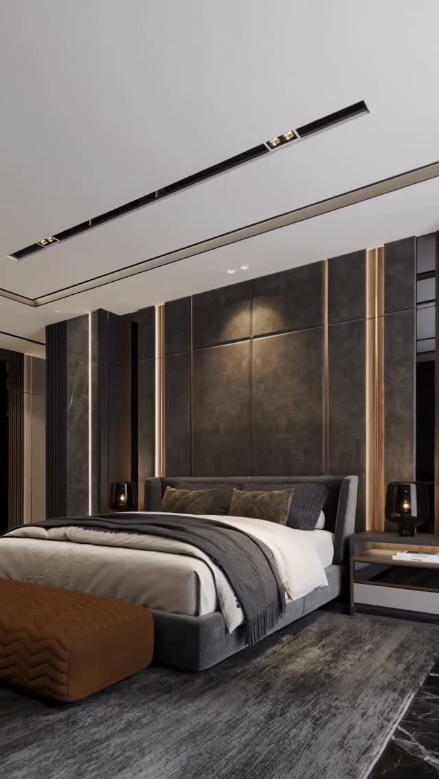 Floor to Ceiling Wall Paneling: 9 Rooms That Get It Right 9 Dark grey wall paneling with gold accents behind a modern grey bed in a bedroom.