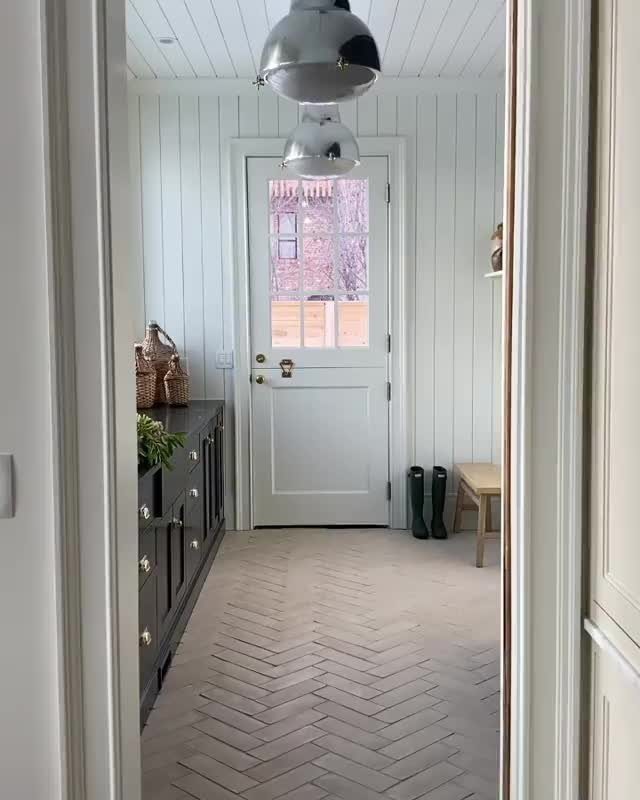 Floor to Ceiling Wall Paneling: 9 Rooms That Get It Right 6 White vertical shiplap walls and ceiling in a bright, narrow hallway with a white door.