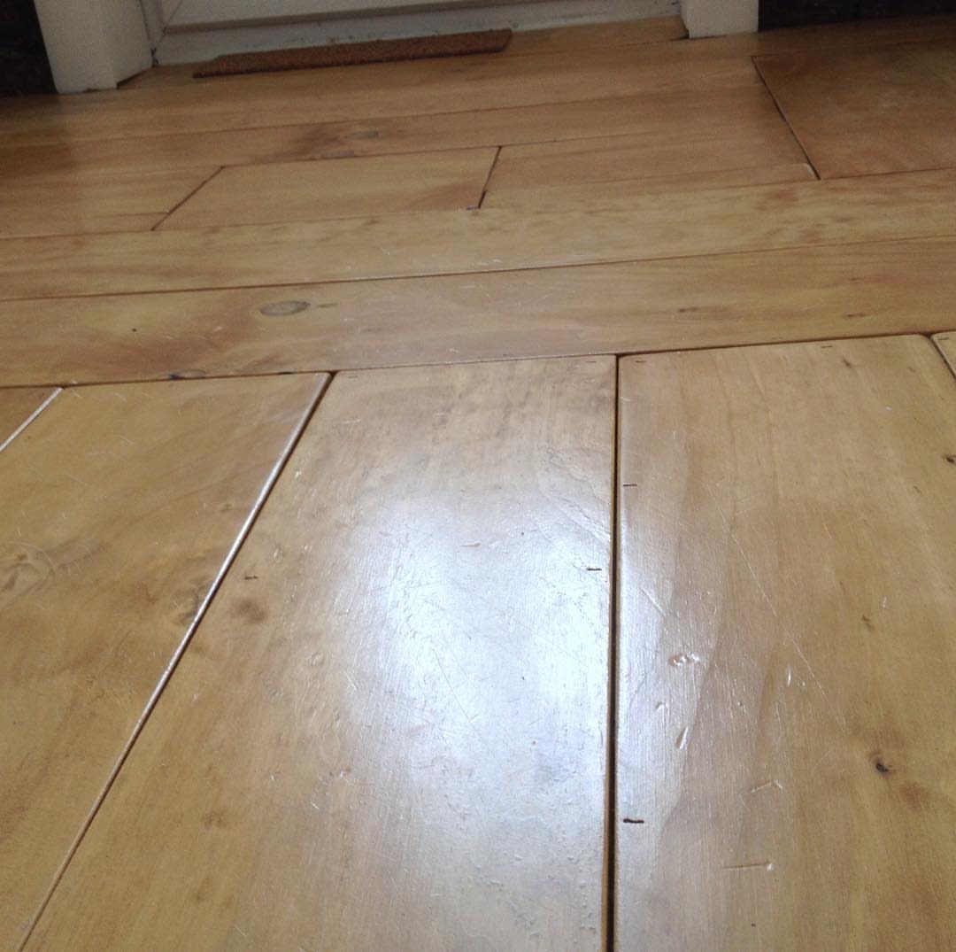 Light-colored wooden planks with visible grain and knots covering a room floor.