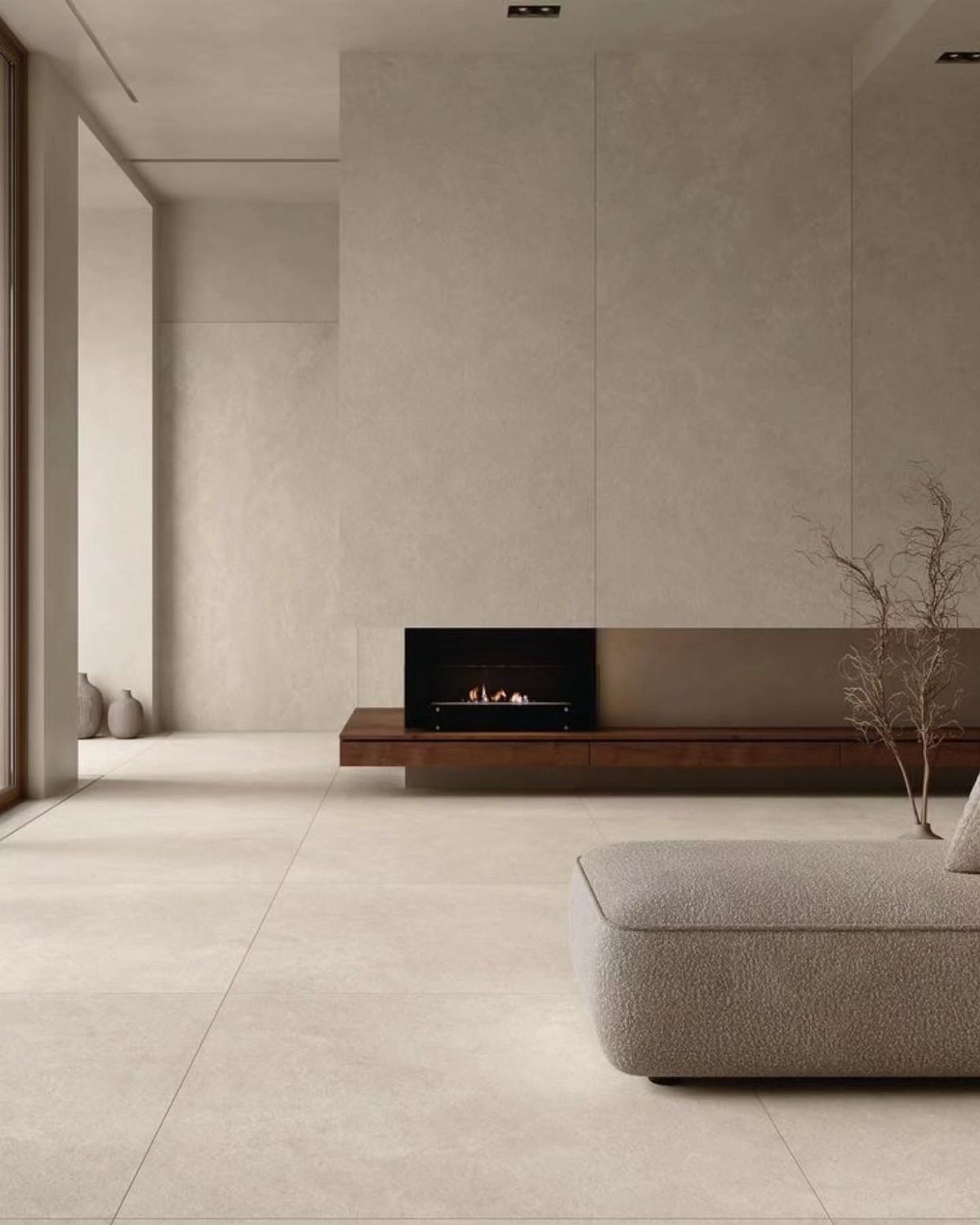 Flooring Trends 2026: 10 Ideas for Warmth, Texture, and Contrast 5 Large light beige matte floor tiles in a minimalist living room with a fireplace.