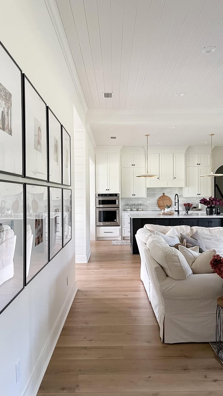 Flooring Trends 2026: 10 Ideas for Warmth, Texture, and Contrast 3 Light wood wide plank flooring in a bright, modern open-concept living room and kitchen area.