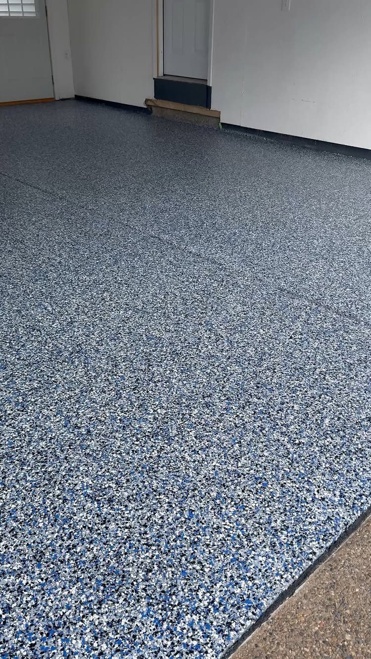 A garage floor with a blue and grey decorative flake coating finish.