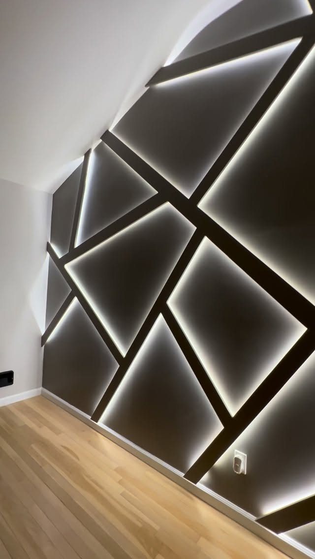 Geometric Accent Wall: 11 Ideas in Wood, Paint, and Light 10 Geometric accent wall with glowing white light strips forming dark angular patterns.