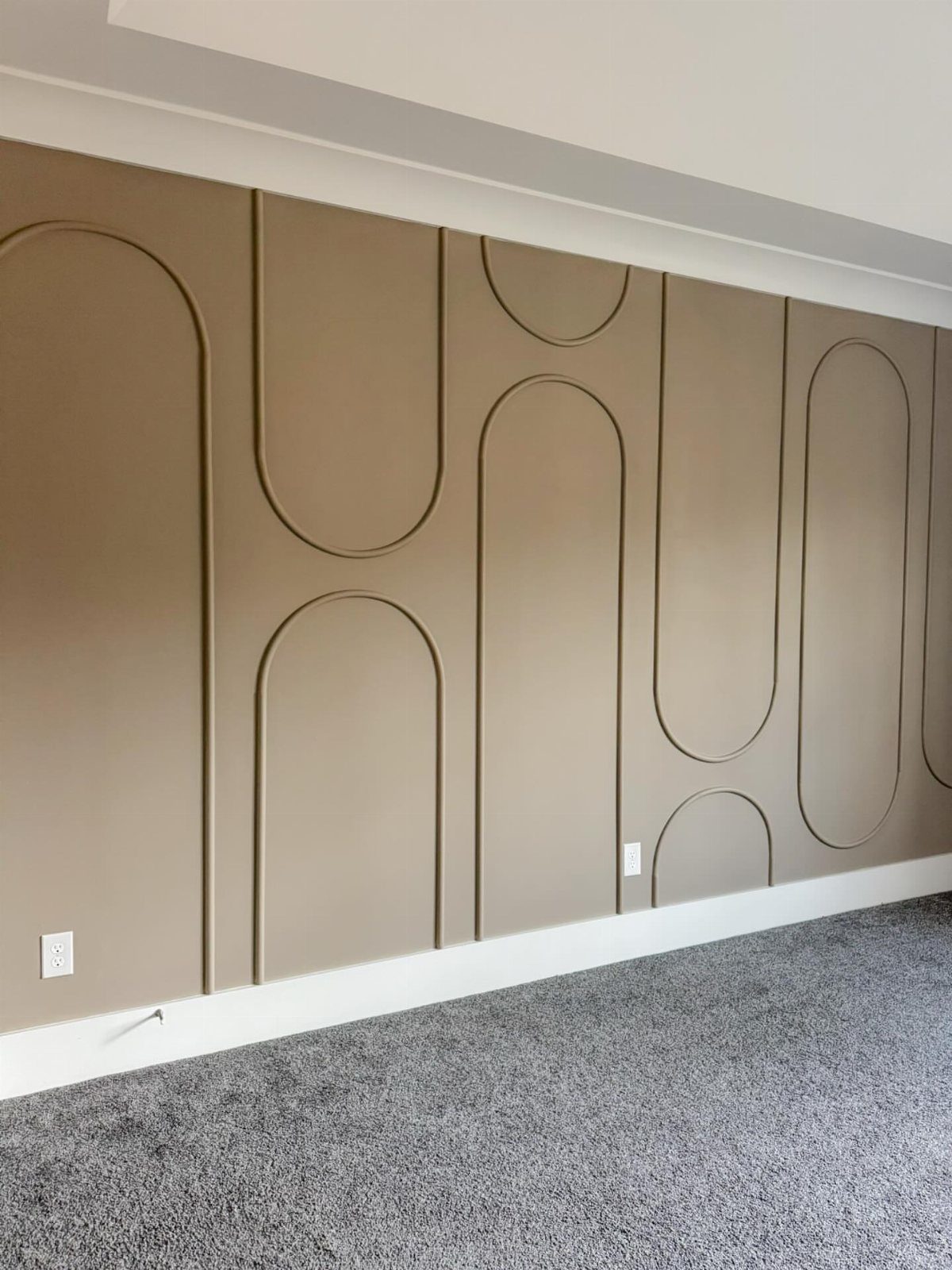 Geometric Accent Wall: 11 Ideas in Wood, Paint, and Light 12 Beige wall with large raised geometric arch and capsule shaped molding patterns.
