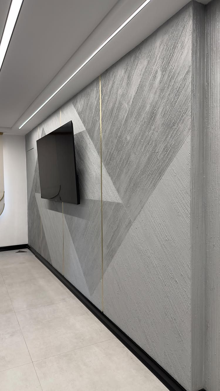 Geometric Accent Wall: 11 Ideas in Wood, Paint, and Light 8 Grey textured geometric accent wall with a mounted black television in a modern room.