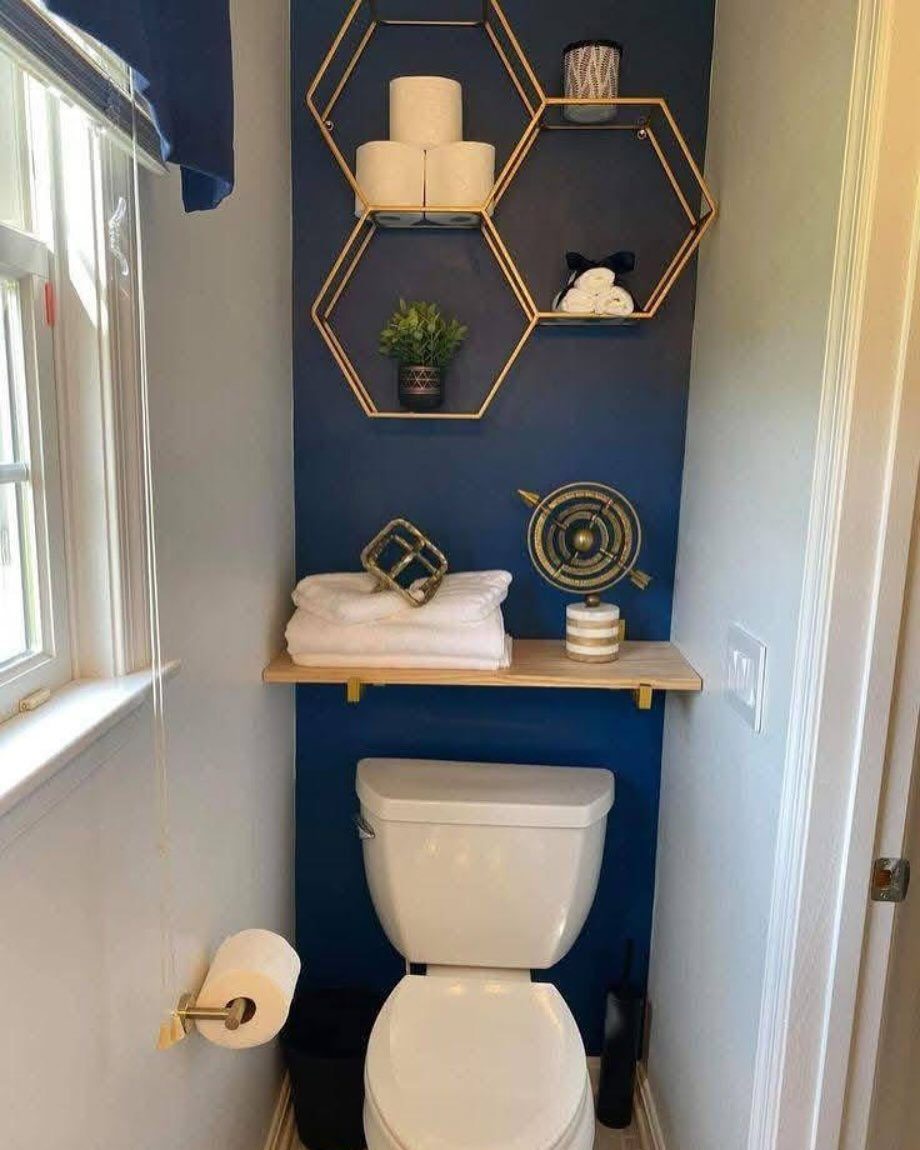 12 Half Bath Accent Wall Ideas That Work in Tight Spaces 9 A deep blue accent wall in a small bathroom with gold hexagonal shelves and white toilet.