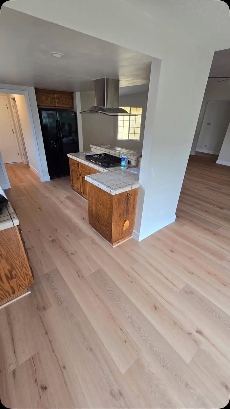 10 Hardwood Flooring Ideas for Every Room Style 7 Light-colored wide plank wood flooring installed in a kitchen and hallway area.