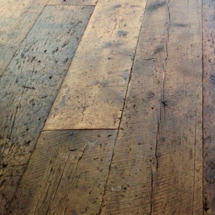 10 Hardwood Flooring Ideas for Every Room Style 8 Reclaimed hardwood floor planks showing rustic textures and visible saw marks in natural brown tones.