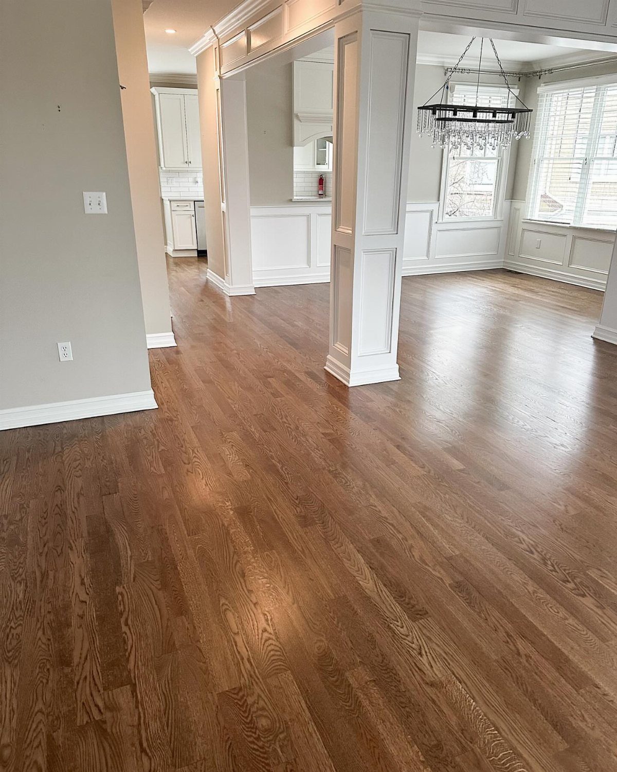 10 Hardwood Flooring Ideas for Every Room Style 5 Medium brown hardwood flooring stretching through a bright, modern open-concept home interior.