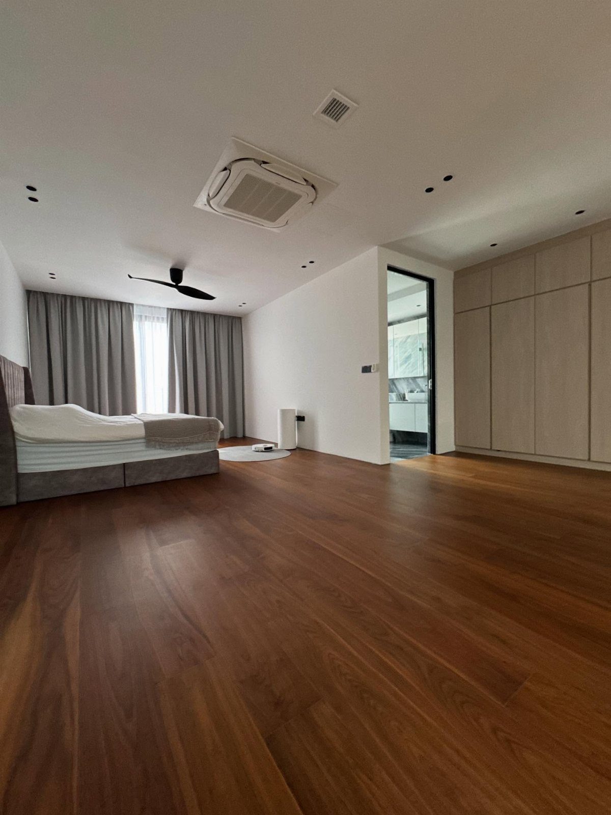 10 Hardwood Flooring Ideas for Every Room Style 3 Dark walnut hardwood flooring in a modern bedroom with a grey bed and white walls.