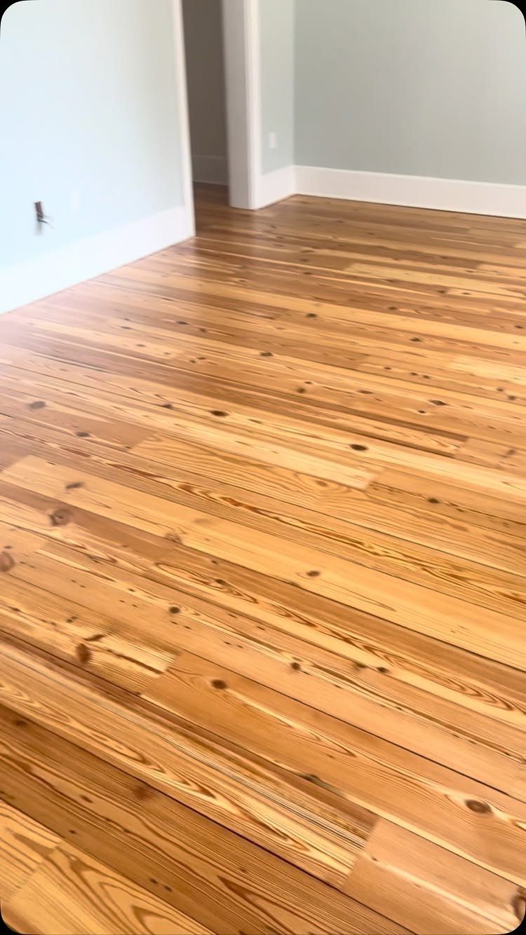 10 Hardwood Flooring Ideas for Every Room Style 9 Wide plank heart pine wood flooring with natural knots in a room with white baseboards.