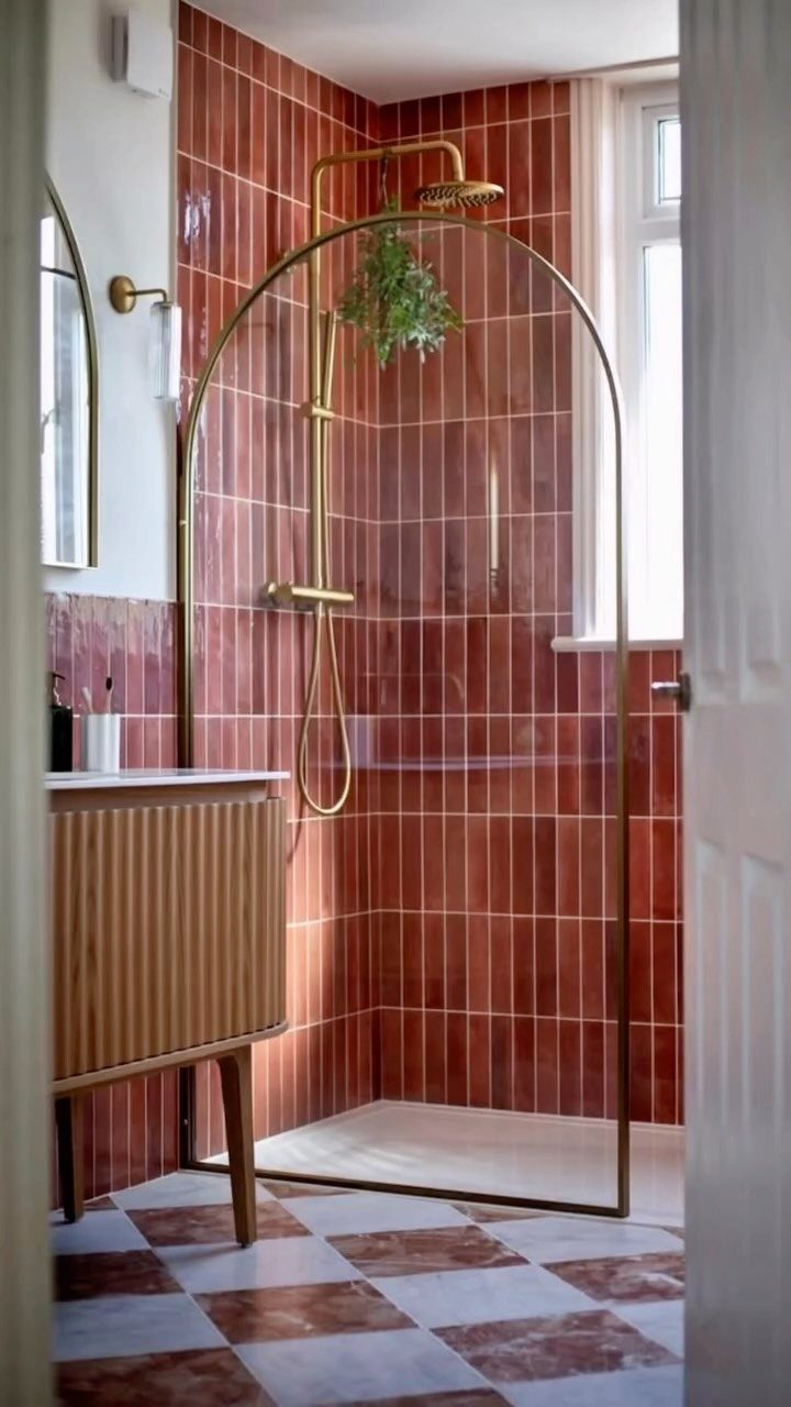 Reddish-brown subway tiles on bathroom walls and checkered marble tiles on the floor.