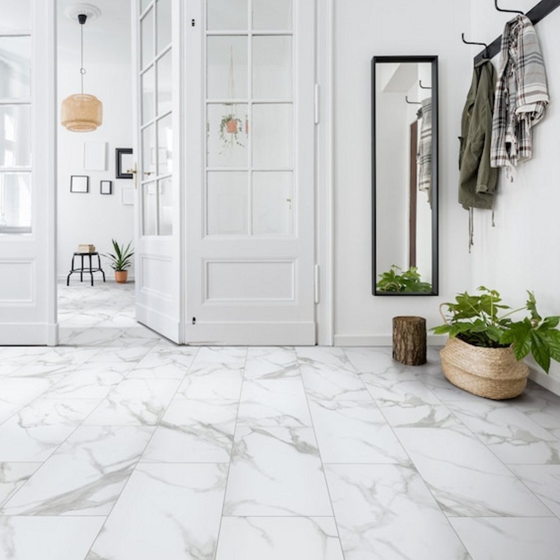 White marble-patterned tiles in a bright hallway with white doors and a potted plant.