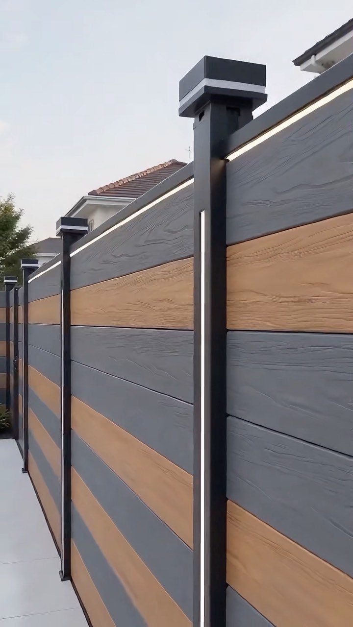 Horizontal Slat Fence: 8 Designs for Modern Backyards 9 Modern horizontal slat fence with grey and wood-textured planks and illuminated dark posts.