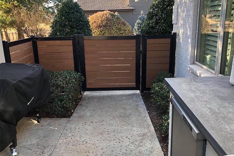 Horizontal Slat Fence: 8 Designs for Modern Backyards 7 Horizontal wooden slats set within a black metal frame forming a modern privacy fence.