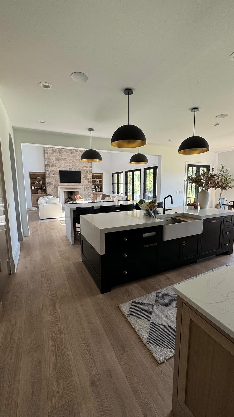 Light Wood Flooring: 10 Ideas That Actually Work 6 Light wood flooring in a modern kitchen with dark cabinets and black pendant lights.