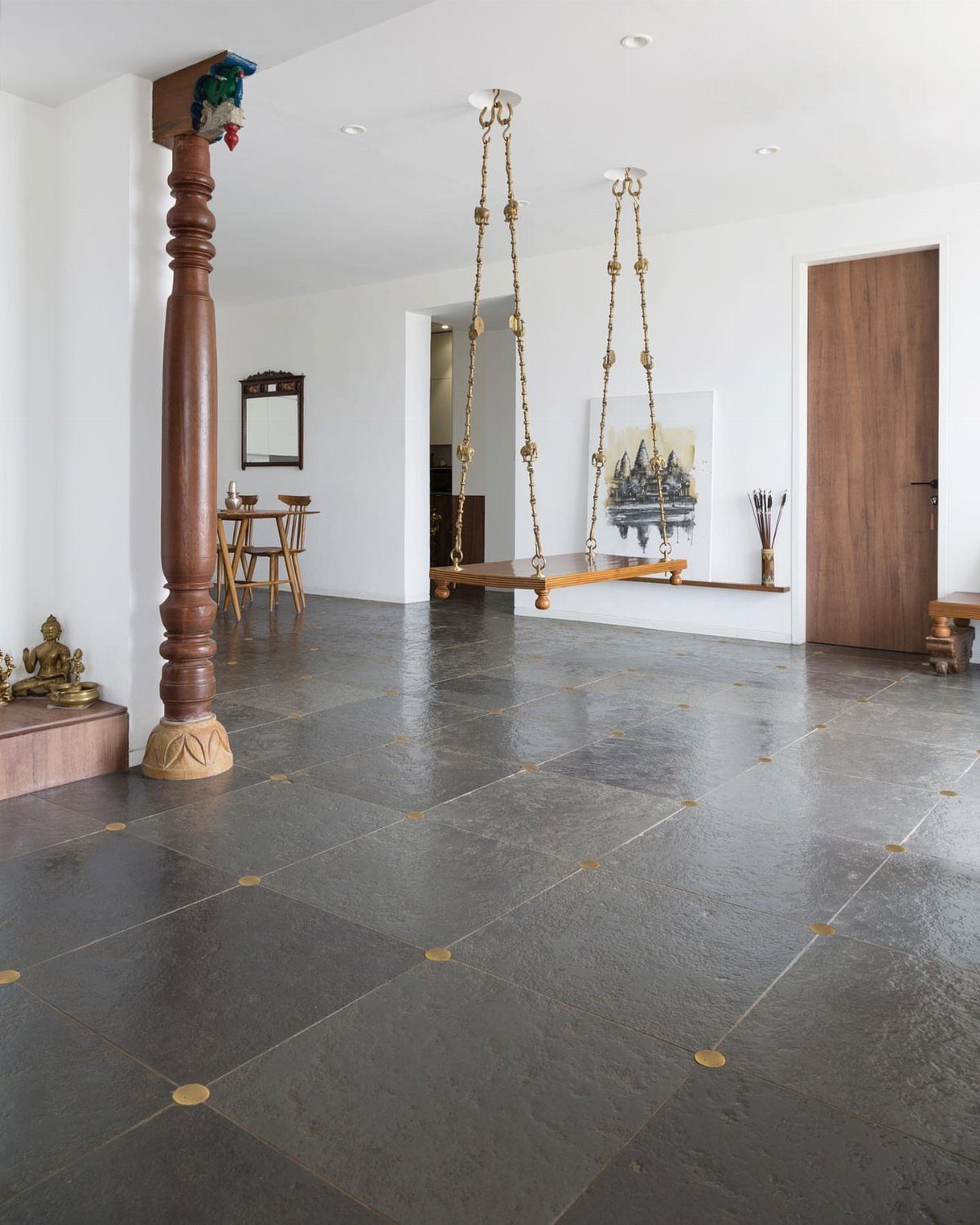 Dark gray stone floor tiles with gold circular accents in a bright room.