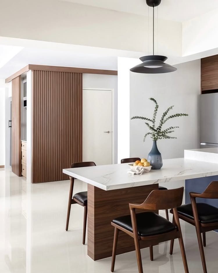 Vertical brown fluted wood paneling on a wall in a modern dining room setting.