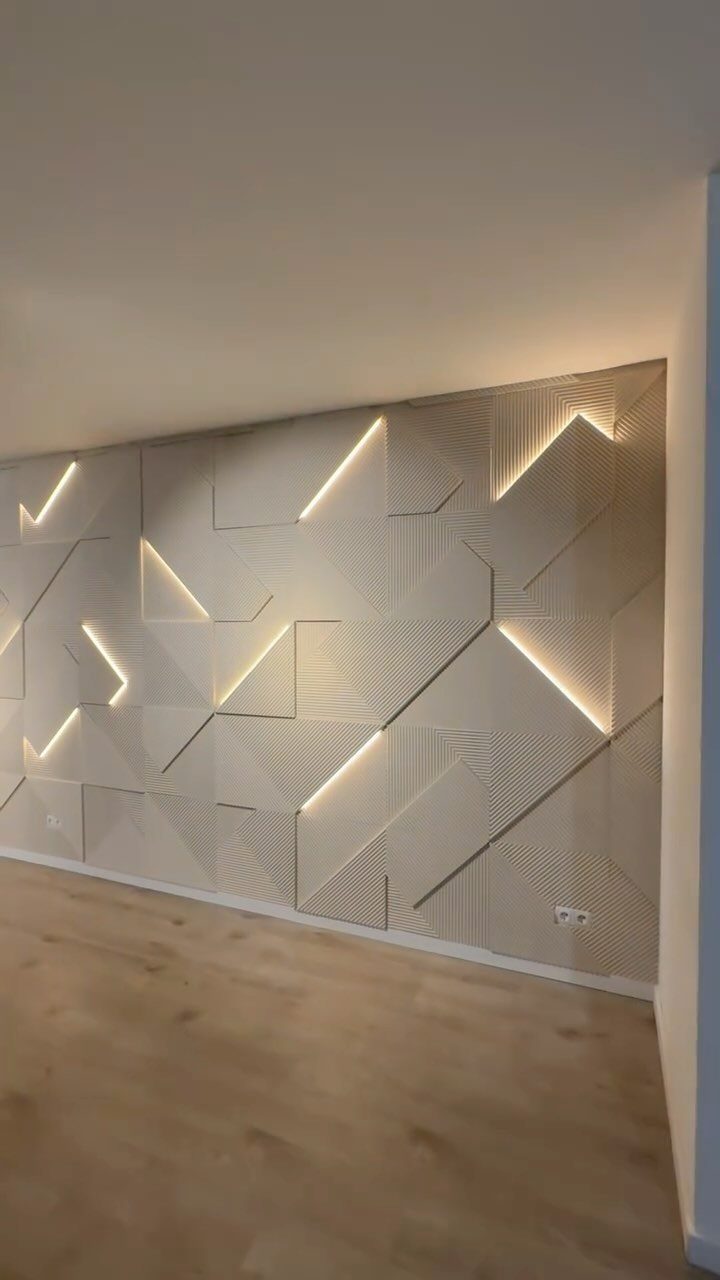 Geometric beige wall panels with integrated LED light strips creating a glowing angular pattern.