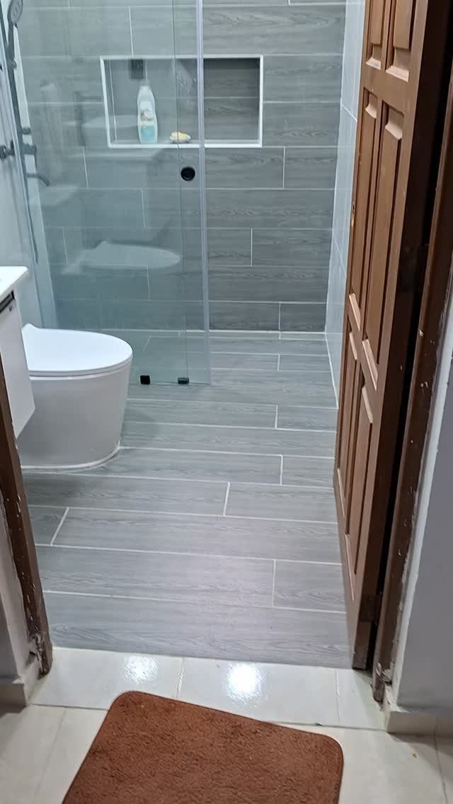 Gray wood-look tiles covering the floor and walls of a modern bathroom interior.