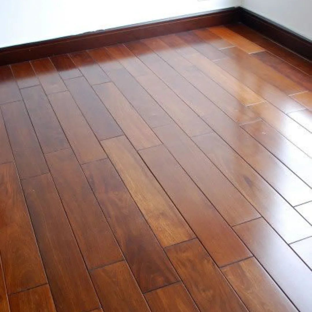 Dark brown polished wood planks installed as flooring in a room with white walls.