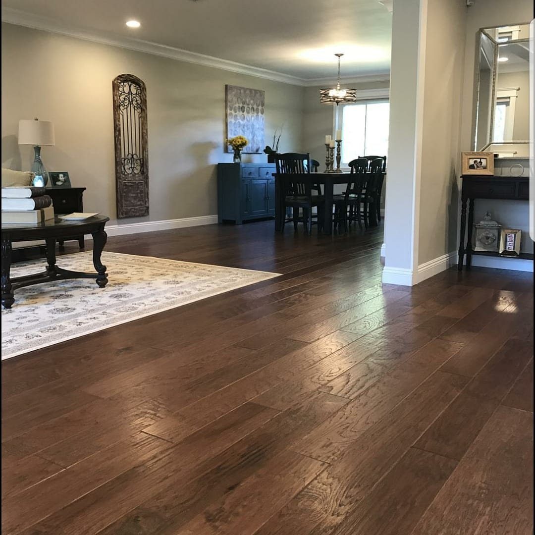 Wood Floor Colors: 5 Ideas for Every Room in 2026 2 Dark brown hardwood floors stretching through a living and dining room area.