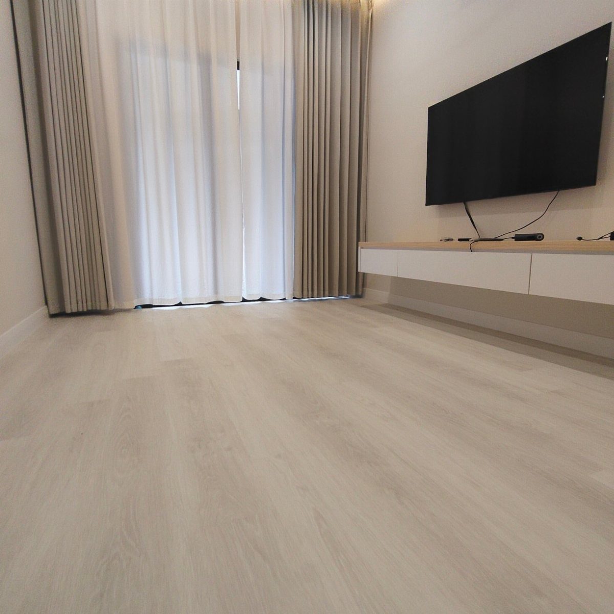 Wood Floor Colors: 5 Ideas for Every Room in 2026 3 Light whitewashed wood plank flooring in a bright, modern living room with white walls.