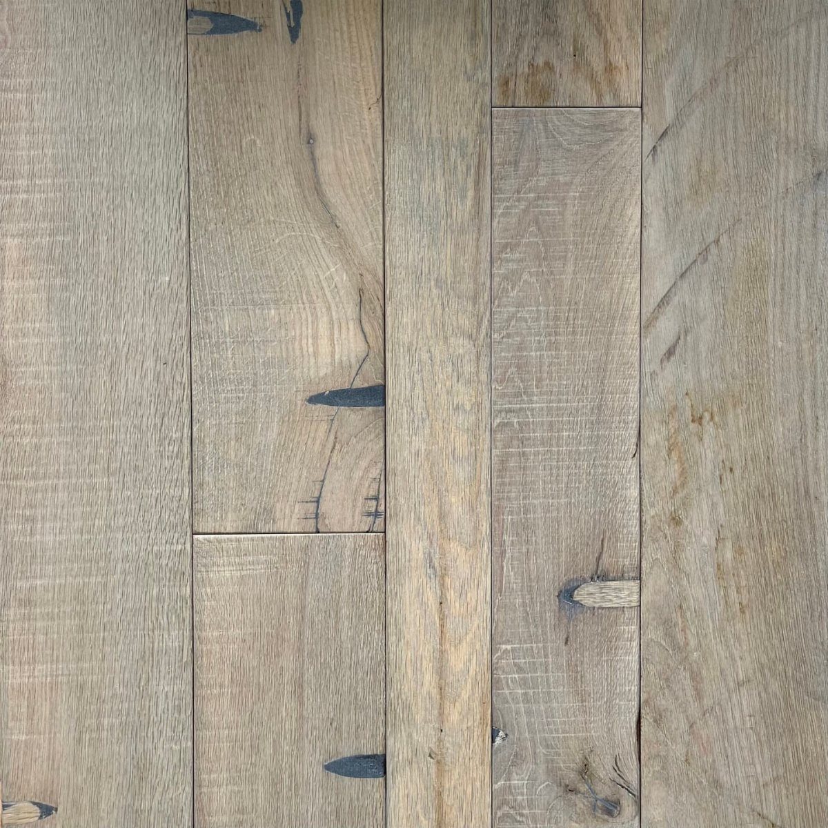Weathered light grey wooden floor planks with visible grain and natural knots.