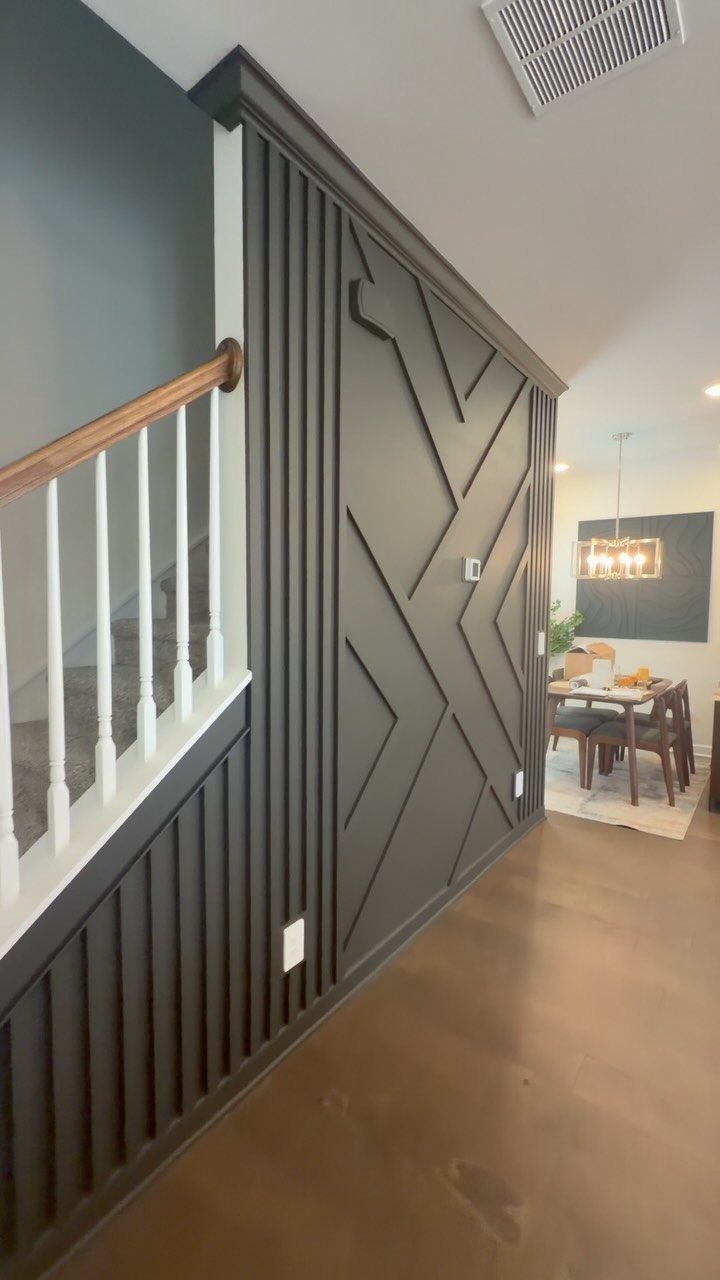 Dark grey wall featuring a geometric wood trim design with diagonal lines and vertical slats.