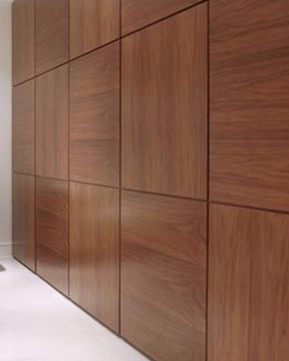 Large rectangular wood panels with a brown grain pattern arranged in a grid on a wall.