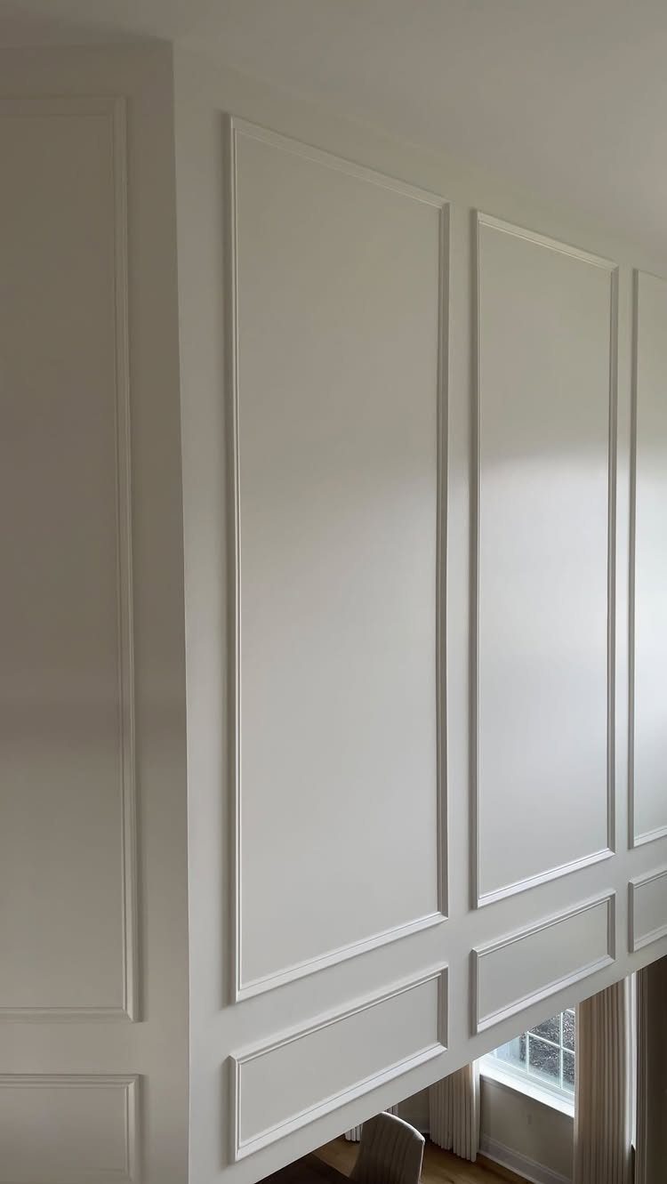 White walls decorated with elegant picture frame moulding and lower wainscoting panels.