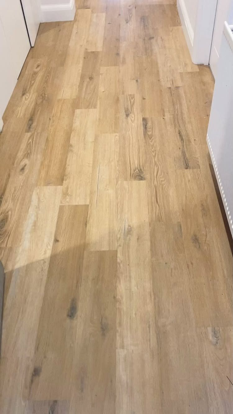 Wooden Flooring Design: 9 Ideas for Every Room 6 Light-toned wooden planks laid in a straight pattern across a hallway floor.
