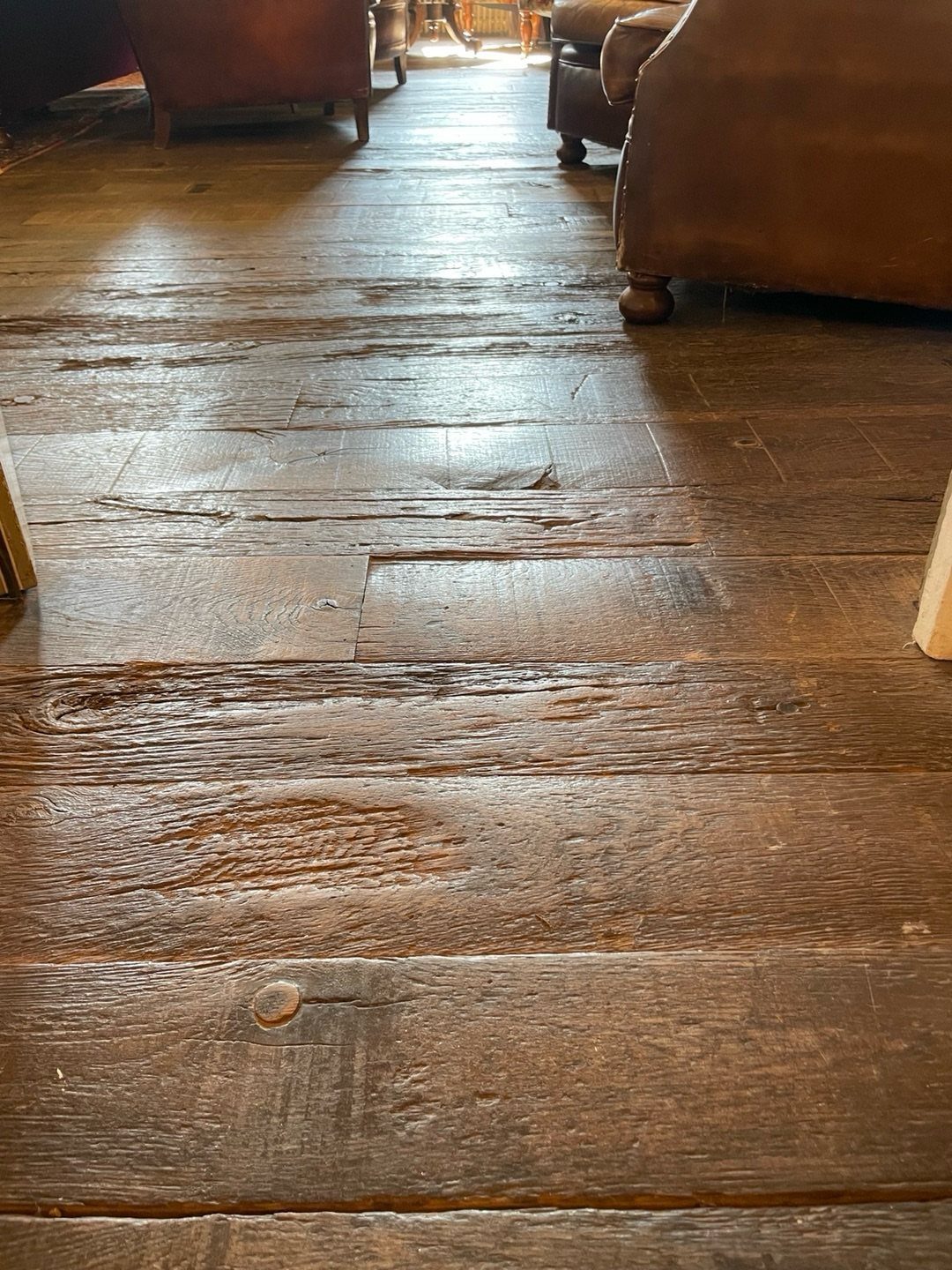 Wooden Flooring Design: 9 Ideas for Every Room 3 Wide reclaimed wooden floor planks with rustic textures and dark brown finish in a living room.